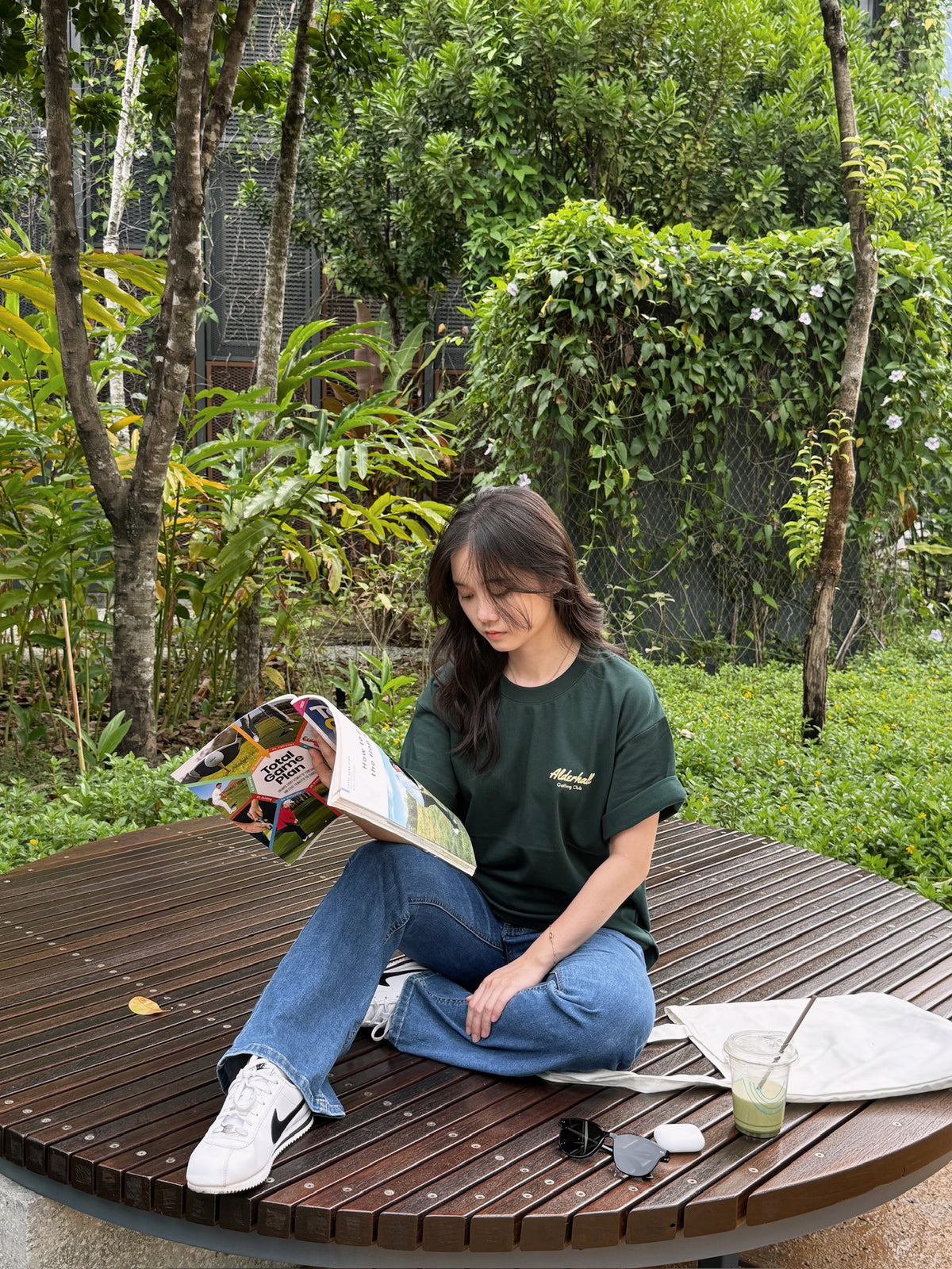 Alderhall Golf Matcha Mock Neck Tee Worn by Model While Reading Golf Magazine 
